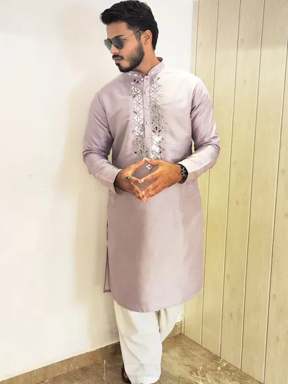 Lavender is a fresh and trendy color for wedding functions. This kurta features intricate mirror work around the neckline, adding a touch of sparkle to a soft and elegant look.