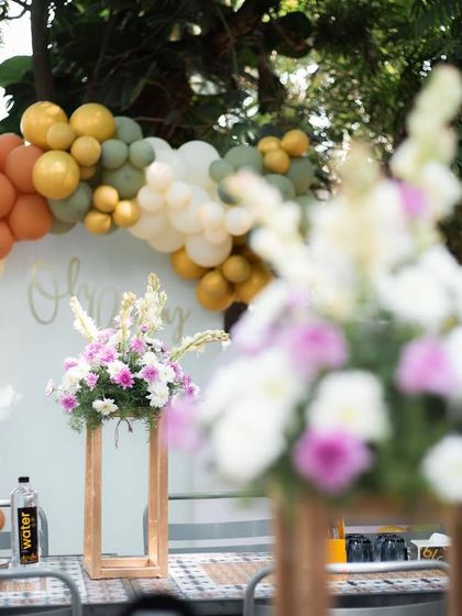 The full view of the baby shower setup, with floral arrangements and a modern backdrop, creating a beautiful and welcoming space for the celebration.