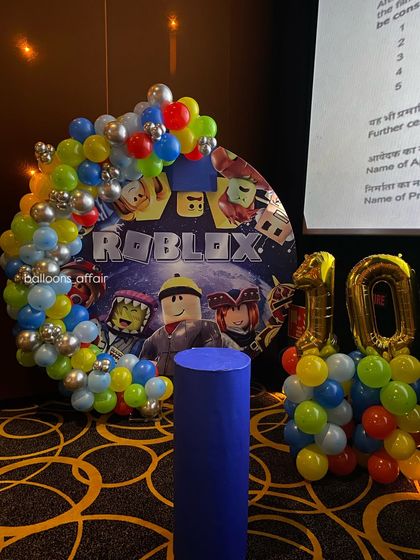 A closer look at the Roblox party backdrop, framed by a vibrant balloon arch with primary colors and silver accents.