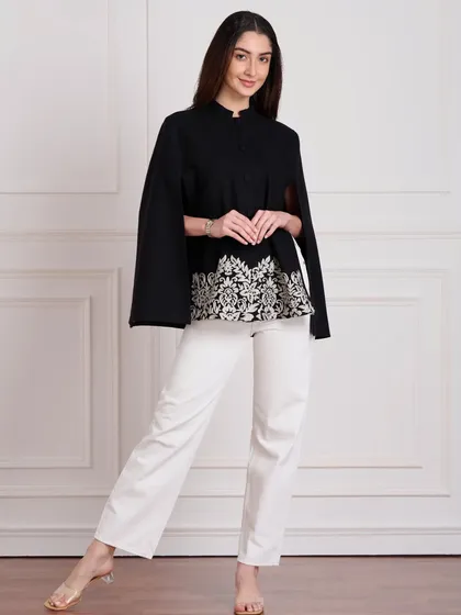 Clean, effective lookbook photography is essential for e-commerce. This shot uses a simple white background and balanced lighting to present the garment clearly, focusing on the silhouette and embroidered details of the cape top without any distractions.