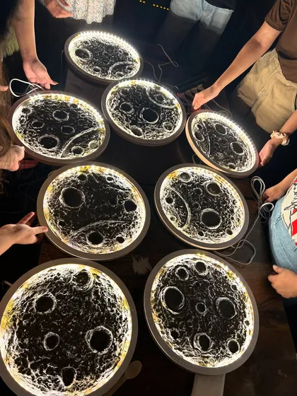 A stunning top-down shot of a collection of finished moon lamps, all lit up and creating a celestial display on the table.