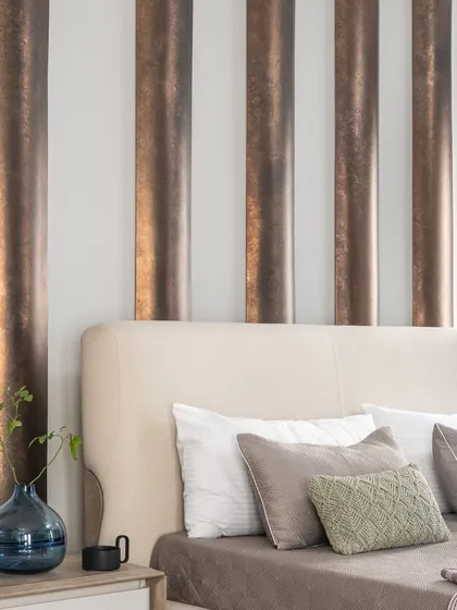 In our modern loft, we created a serene master bedroom with a monotonous theme. The headboard features curved metal panels, adding a unique character and artistic flair to the space.