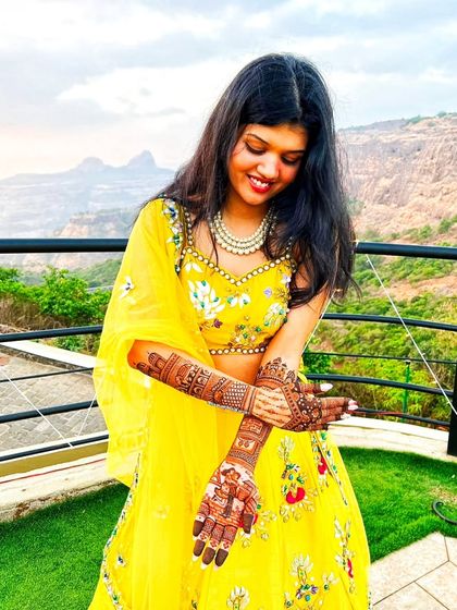 A close-up of the bride from the previous image, admiring her intricate henna.
