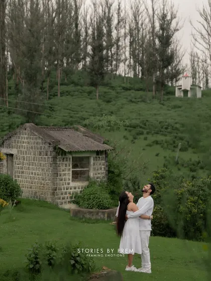 A romantic embrace next to a charming stone cottage in the hills. This image has a timeless, storybook quality, perfectly capturing the magic of a destination shoot in Ooty.