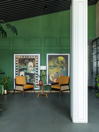 Another view of the Primus lounge, highlighting our custom designed armchairs with cane weaving against a rich green wall. The design blends natural materials and soothing colors to foster a sense of well being.