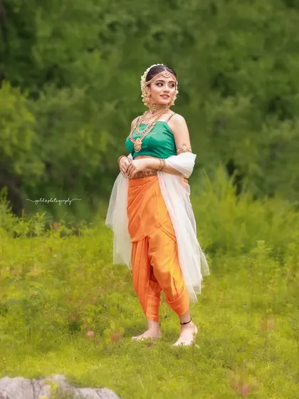 A full-length shot of the Sakhi look in a wide, natural landscape, giving it a grand and majestic feel.