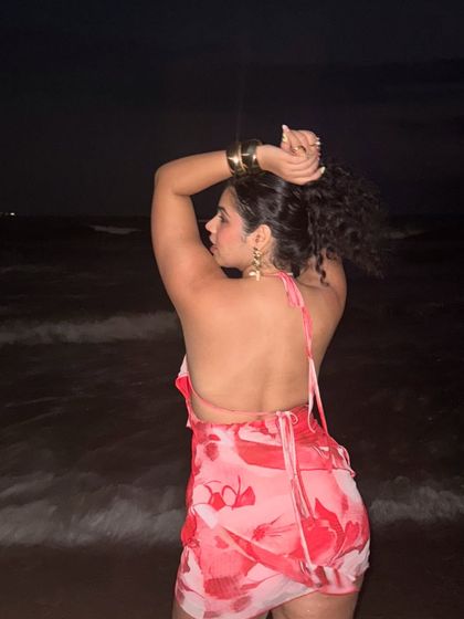 A back view of my halter dress on the beach at night. The open back and messy bun create a relaxed, beachy-chic look.
