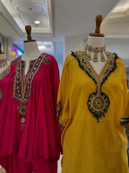This pairing of a pink kaftan and a yellow kurta set shows how different silhouettes can share a common festive spirit through bold color and intricate detailing.