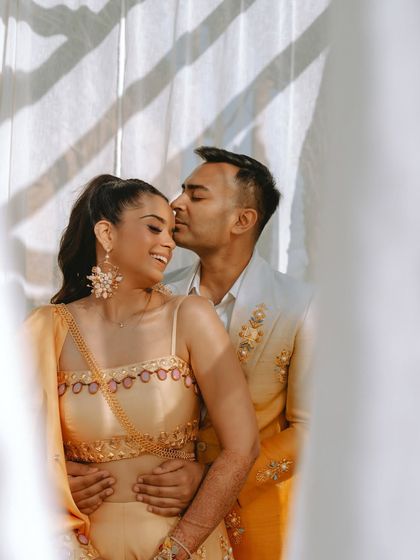 A tender kiss on the cheek, beautifully lit by the sun, capturing a soft and romantic moment.