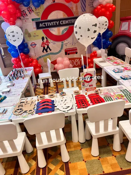 A London-themed activity center featuring our white tables and chairs. The tables are set up with themed crafts, providing an engaging and creative space for kids during the event.