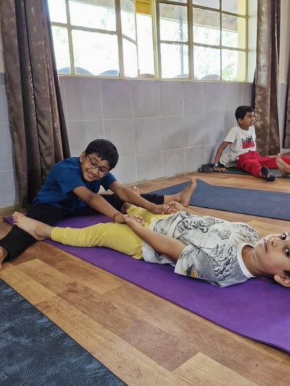 Little yogis learning to support each other. This partner stretch helps develop flexibility and trust, all while sharing a playful moment.