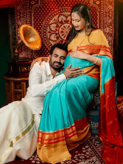 An intimate couple portrait from a traditional maternity session. The father-to-be rests his head on the baby bump, showing a deep connection and anticipation.