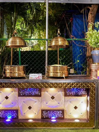 Another angle of our elegant white and gold buffet counters, illuminated with custom lighting to match the event's ambiance.