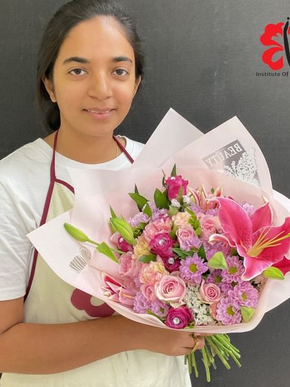 A beautiful hand-tied bouquet in shades of pink, featuring lilies, roses, and carnations. This student learned to create a full, rounded shape using the spiral stem technique.