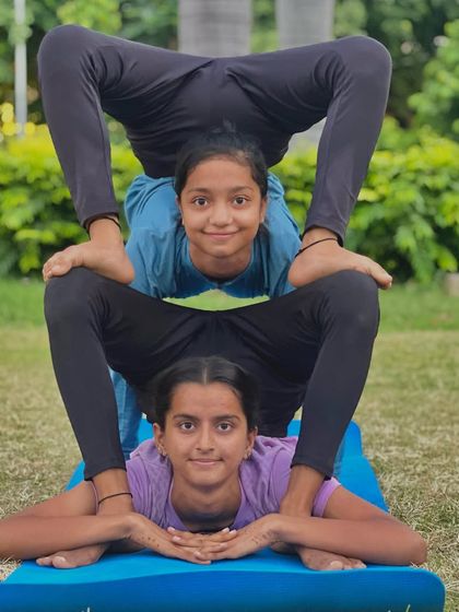 Yoga is for the willing. These two young yogis demonstrate incredible teamwork and flexibility in this stacked partner pose.