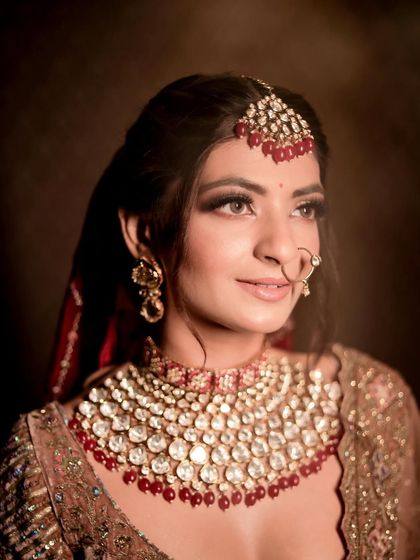 A close-up portrait showcasing the soft smokey eye and perfectly defined features, paired with a stunning ruby necklace.