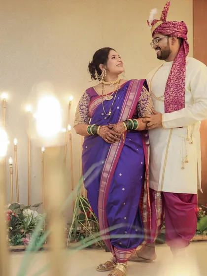 A lovely couple portrait. The bride's purple Nauvari is draped elegantly, allowing her to stand comfortably with her partner.