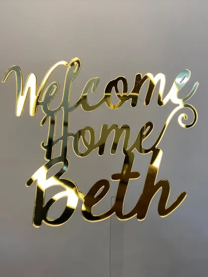 There's no place like home! This "Welcome Home Beth" topper in a beautiful gold script is a sweet way to celebrate someone's return.