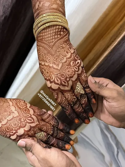A stunningly dark henna stain, complemented by traditional gold bangles. This is the kind of rich color that makes any festive look complete.