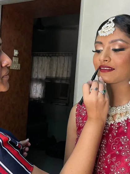 It's all in the details. Here I am putting the final touches on a bride's bold lip, ensuring the application is precise and perfect for her big day. This collaborative process is one of my favorite parts of the job.