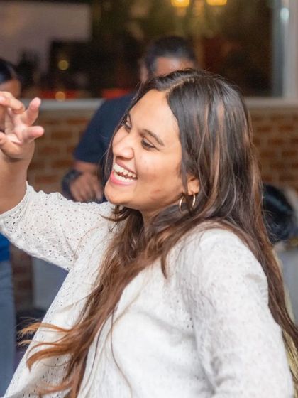 A woman smiling and dancing, captured in a moment of pure joy. This is the atmosphere I cultivate.