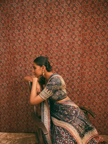 A side profile against a patterned Ajrakh backdrop. This shot emphasizes the synergy between the garment and the environment, a key element of my art direction.