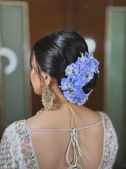 A shot of the stunning floral hair bun, which adds a beautiful touch of color to the overall look.