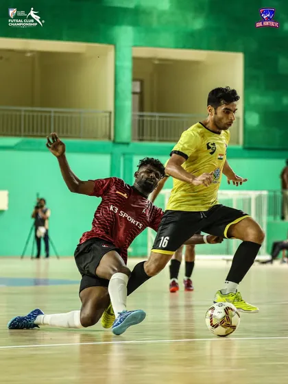 A player trying to dribble past a defender on the ground.