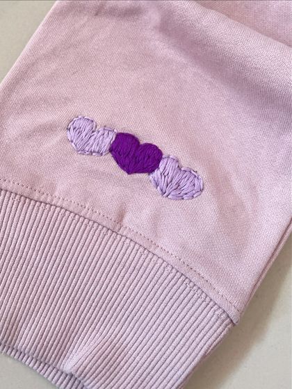 Little details matter. These three embroidered hearts on the cuff of a sweatshirt add a small but sweet touch of color and love.
