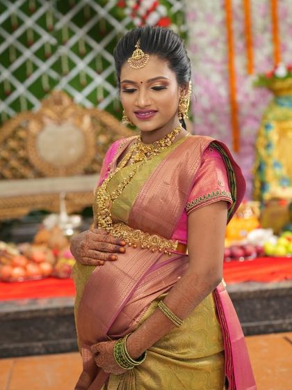 A full view of Malini's baby shower look. The antique gold jewellery beautifully complements her elegant silk saree.