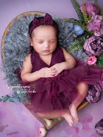 A duplicate of image 136, a beautiful floral and purple-themed newborn portrait.