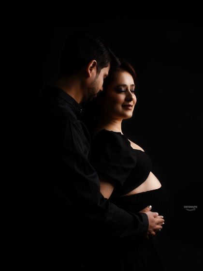 A dark and intimate low-key portrait of a couple embracing. This style uses shadows to create a moody and romantic atmosphere, focusing on their close connection.