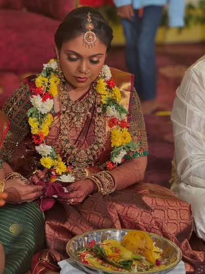 Prithivi participating in her wedding ceremony. This image captures the traditional setting and shows how her makeup and styling hold up beautifully throughout the rituals.