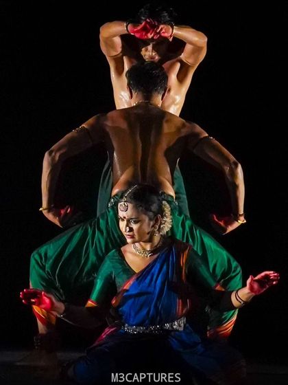 A creative group pose from 'Nagamandala', forming a single entity. This is a powerful example of how group choreography can be used for symbolic representation.