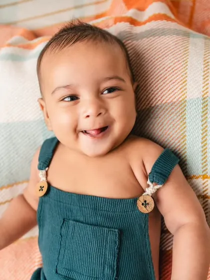 A bright, happy smile from a 3-month-old baby boy. These early milestone sessions are perfect for capturing those first social smiles.