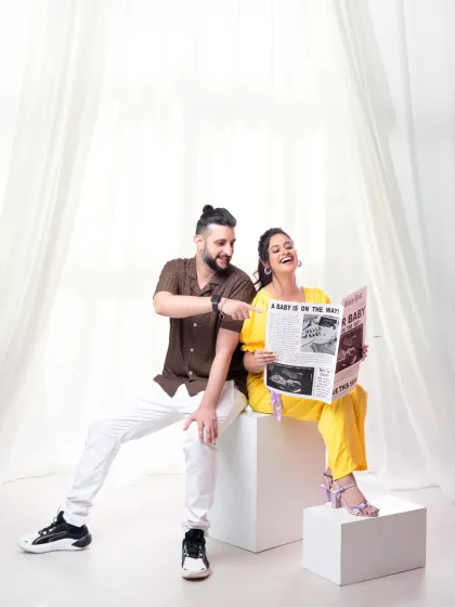 Extra, extra, read all about it! A baby is on the way! This playful couple's shot uses a newspaper prop for a fun and unique pregnancy announcement.