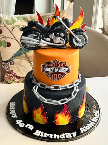 A cake with some serious attitude. This two-tier Harley-Davidson themed creation features a sculpted motorcycle, edible flames, and a bold logo, making it the perfect centerpiece for a 40th birthday with a rebellious spirit.