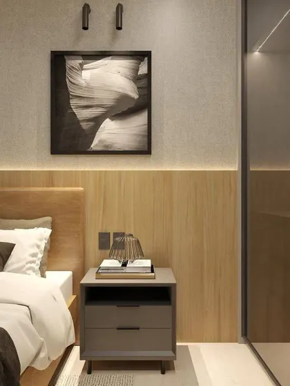A close-up of the bedside area, highlighting the wood paneling, modern art, and the sleek grey nightstand.