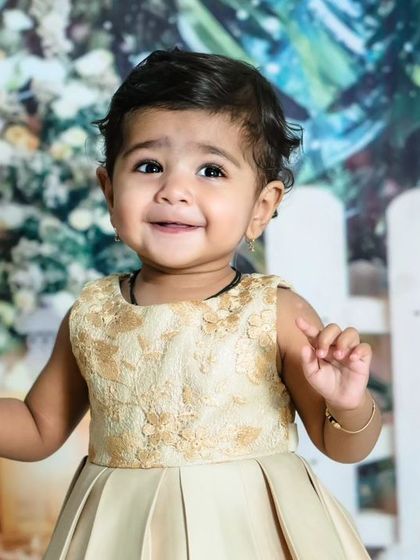 A happy, candid moment from a Christmas mini-session. The baby's joyful expression and the festive 'Winter Wonderland' background make for a perfect holiday card photo.