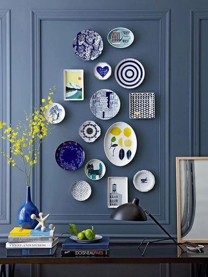 A gallery wall of decorative plates can be a unique form of personal expression. We arranged this collection of blue and white plates of various shapes and patterns against a bold blue wall to create a striking focal point.