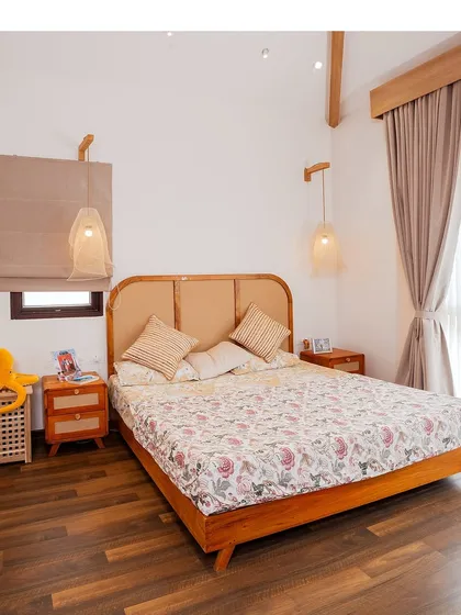 A Japandi-themed bedroom with a low wooden bed, rattan headboard, and simple, nature-inspired decor. The focus is on intention and elegance without excess.