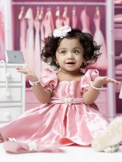 A playful moment in the pink closet, with this little girl sitting amongst pearls and accessories.