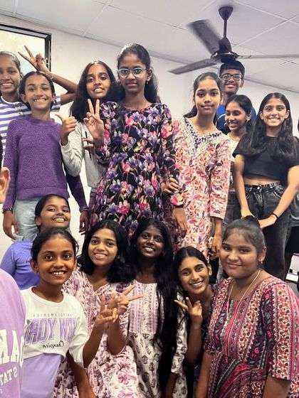A group photo with students standing on benches to fit everyone in. This picture perfectly captures the fun and energy of our Navratri celebrations.