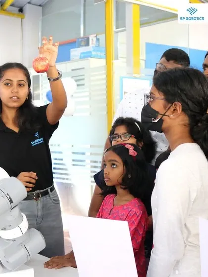 An instructor uses an industrial robotic arm to demonstrate precision and automation to an engaged audience. We expose students to both educational and real-world industrial robotics.