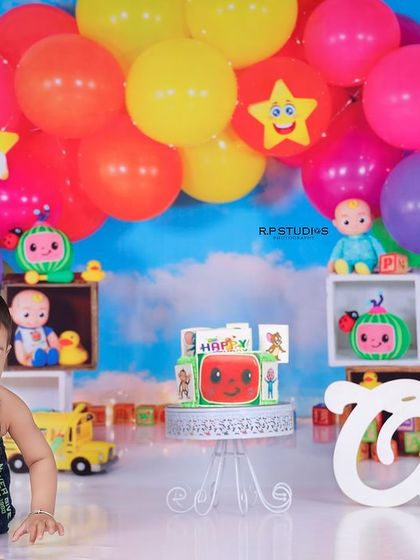 A baby boy crawls towards his Cocomelon cake, ready for a fun and messy celebration. This theme is a hit with little ones and makes for great photos.