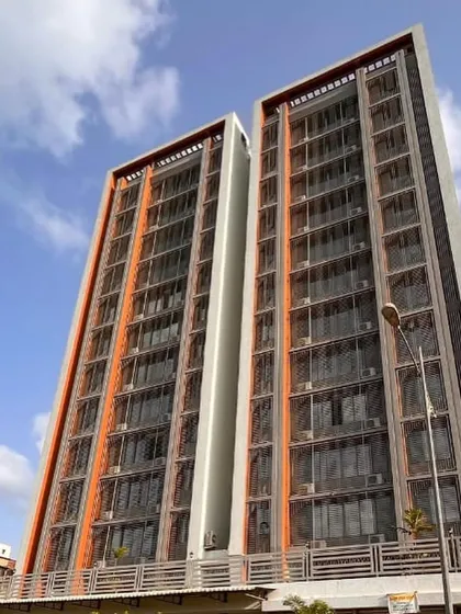 For the 'Dreams Paradise' residential building in Kharghar, we focused on clean lines and a simple, elegant facade. The design uses depth and a restrained color palette of grey and deep squash to create a sophisticated play of light and shadow.