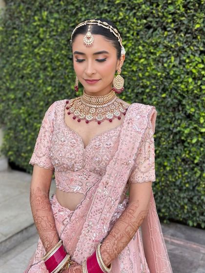 Aarushi was a vision in her pastel pink lehenga for her day wedding. We kept the makeup fresh and radiant, with a clean winged liner and a soft pink lip. These portraits capture the look from every beautiful angle.