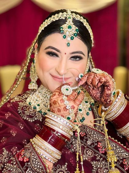 A smiling portrait of the same bride, her happiness shining through. The focus is on her radiant smile and the detailed makeup.