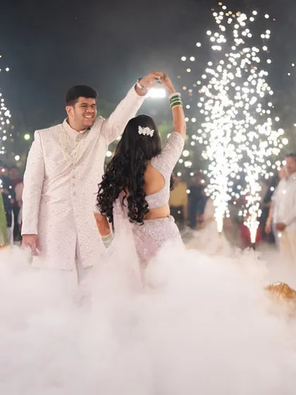 The couple shares their first dance, with the bride's hair and lehenga flowing beautifully as she twirls.