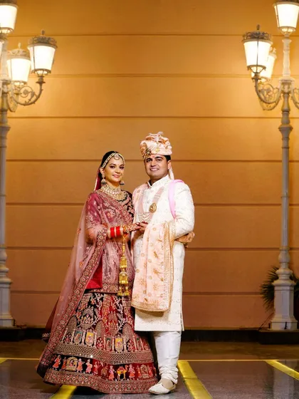 A full-length portrait of the wedding couple against a beautifully lit backdrop. I use the venue's ambiance to create classic and elegant wedding photographs.